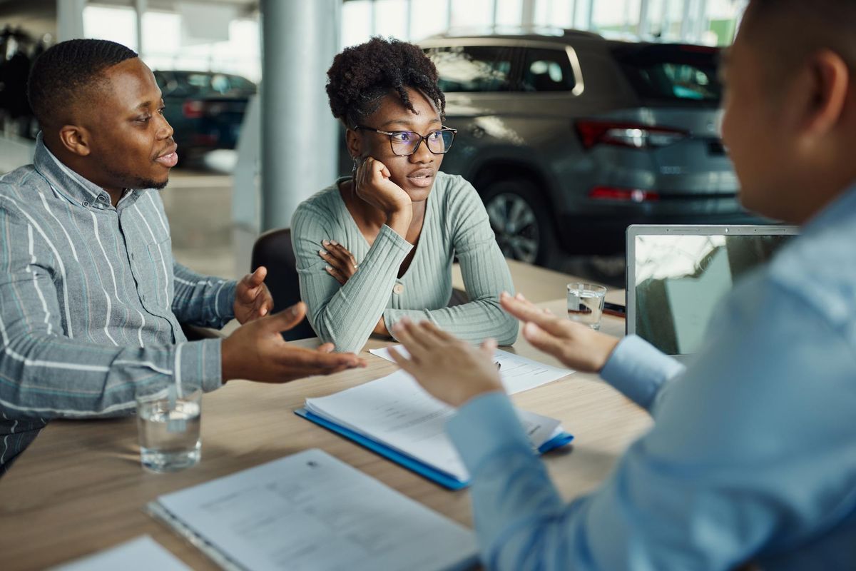 A couple looks concerned at a car dealership