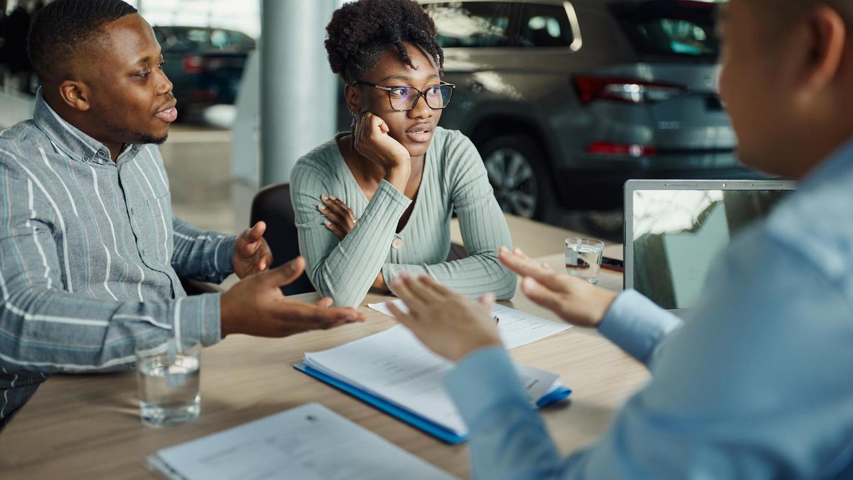 A couple looks concerned at a car dealership