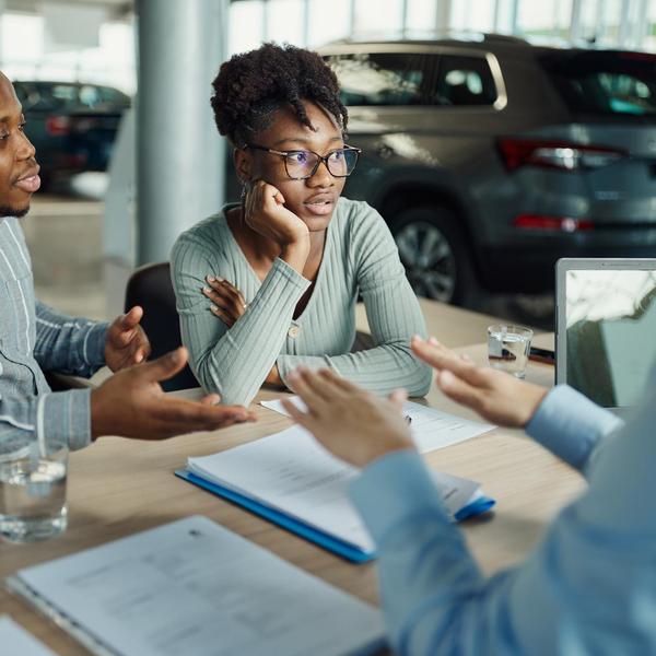 A couple looks concerned at a car dealership