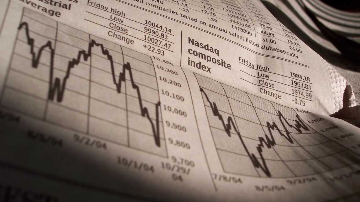 A newspaper shows Dow and Nasdaq index performance on a certain day