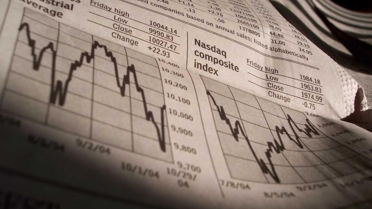 A newspaper shows Dow and Nasdaq index performance on a certain day