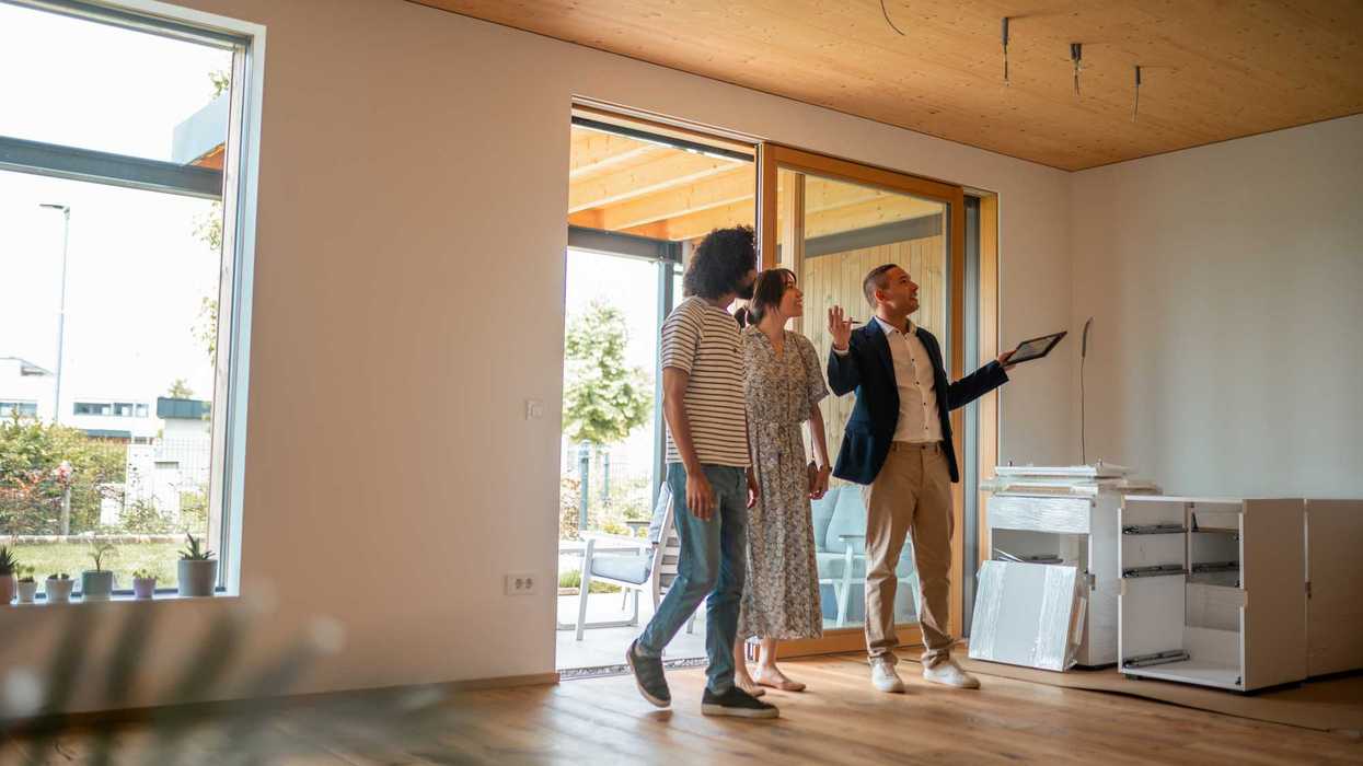 A real estate agent shows a home to a couple looking to buy