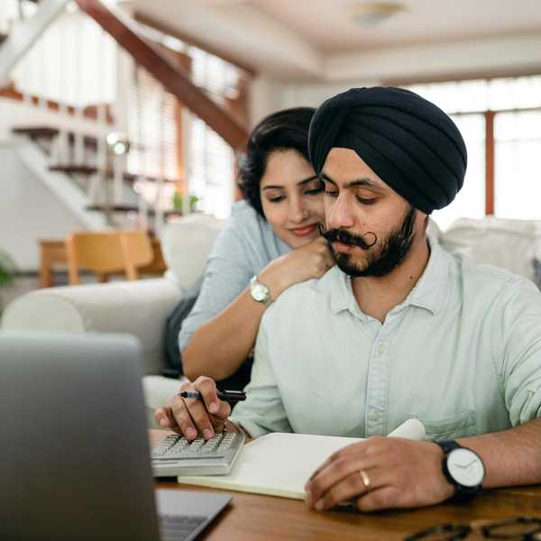 A South Asian couple reviews finances together at a home desk