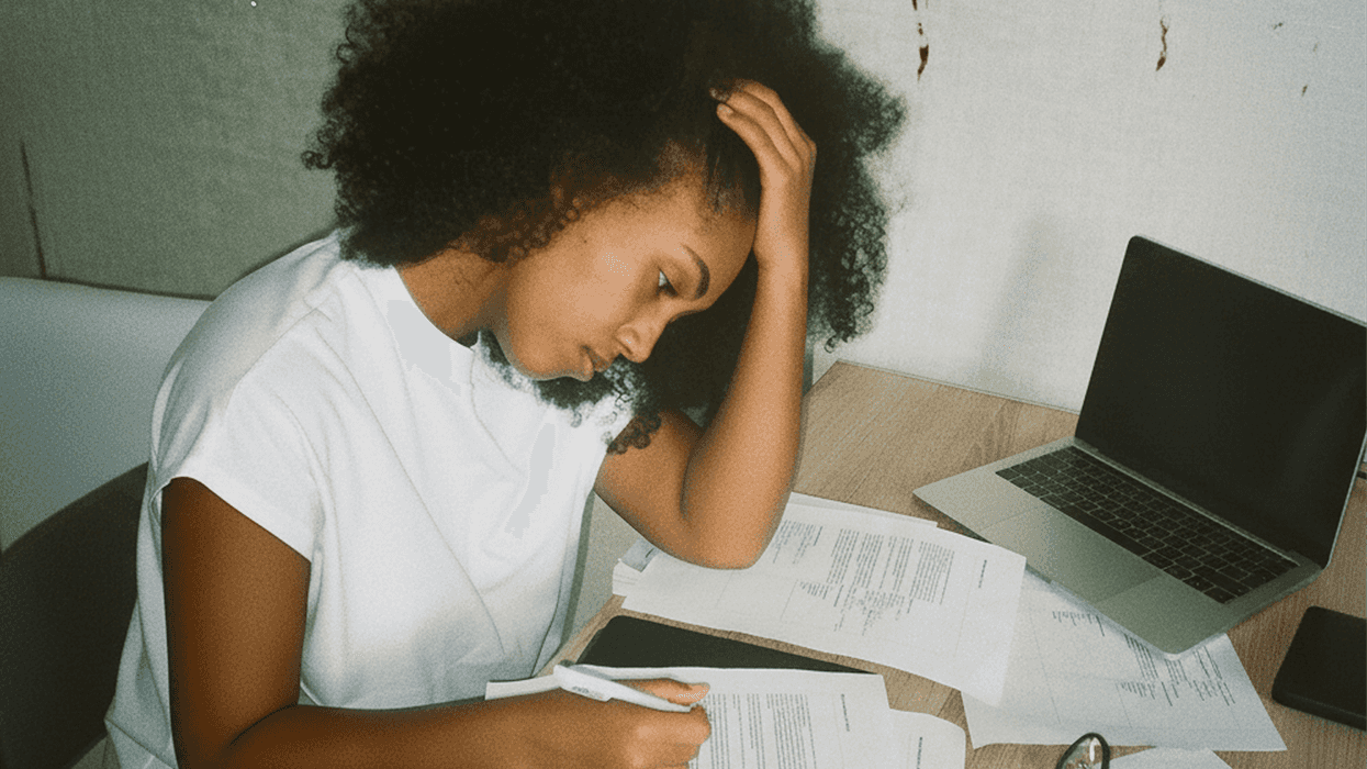 A stressed woman filling out piles of paperwork