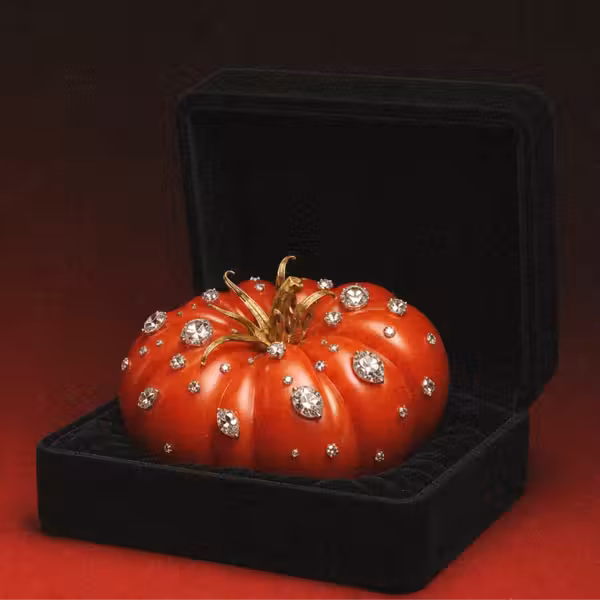 A tomato covered in diamonds, sitting in a jewelry box