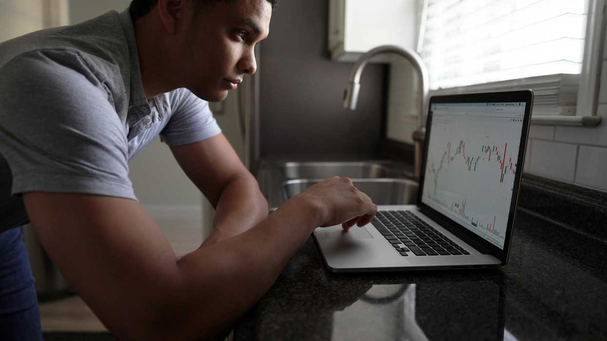 A young investor checks his portfolio on his computer at home
