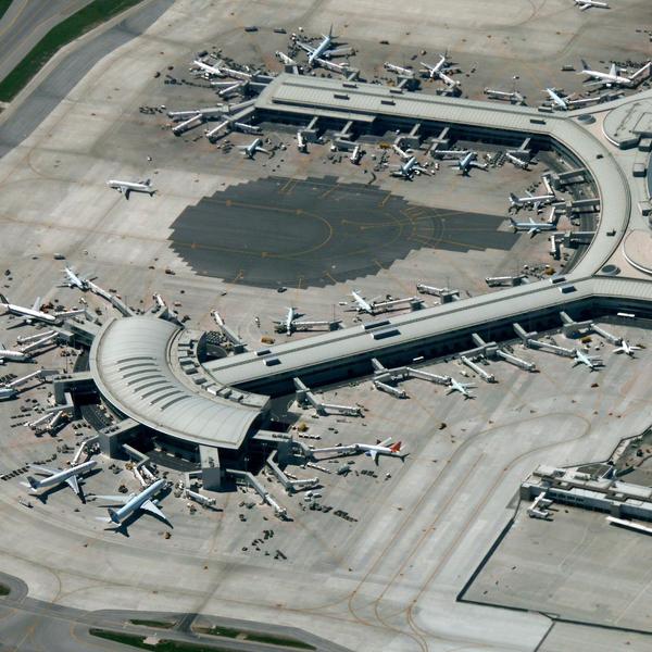 An aerial view of Toronto's Pearson Airport showing many planes docked at gates.