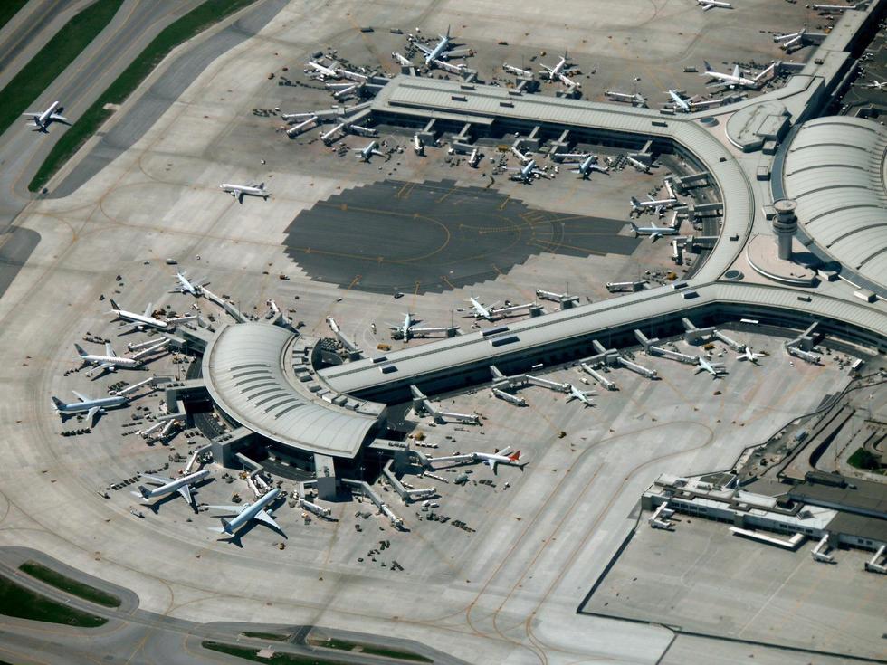 An aerial view of Toronto's Pearson Airport showing many planes docked at gates.