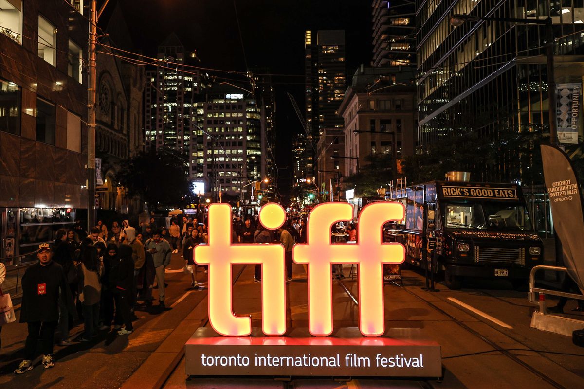 An illuminated sign for TIFF sits on a pedestrianized street in downtown Toronto.
