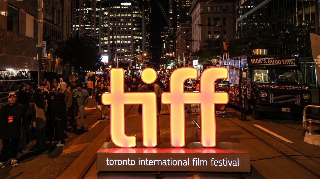 An illuminated sign for TIFF sits on a pedestrianized street in downtown Toronto.