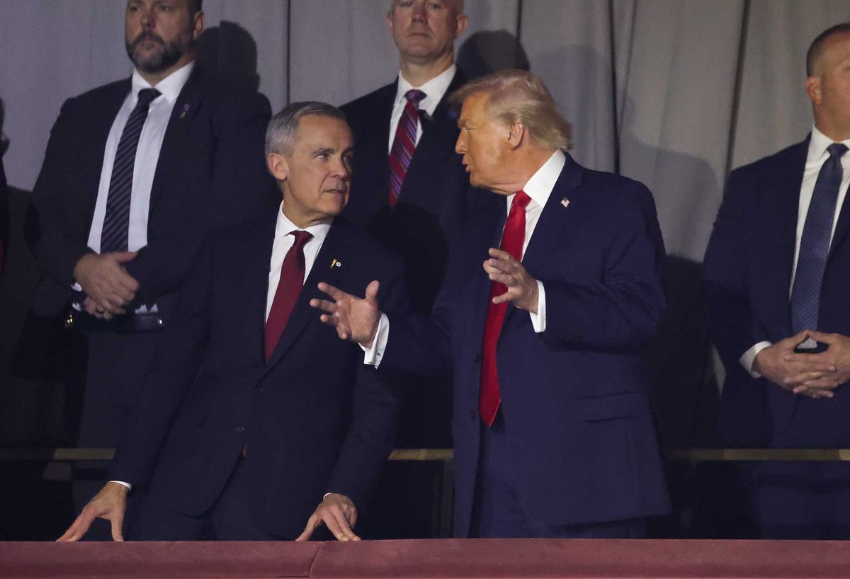 Canadian Prime Minister Mark Carney stands next to US President Donald Trump at an event