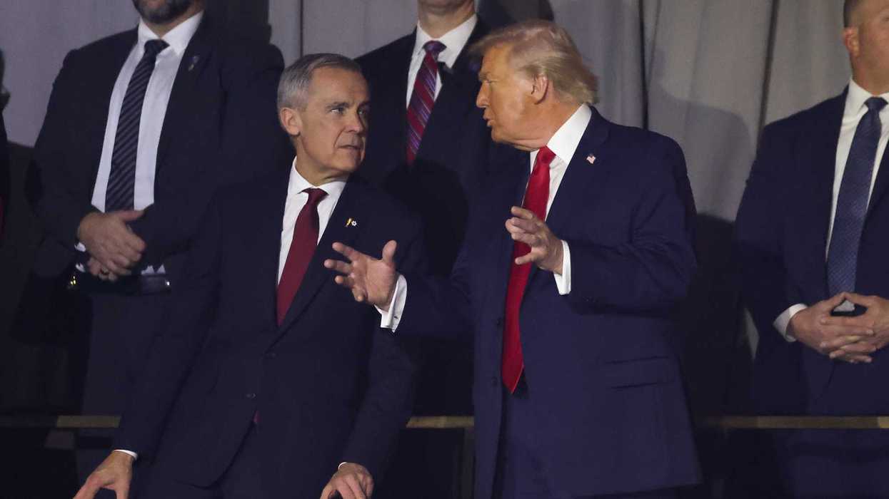 Canadian Prime Minister Mark Carney stands next to US President Donald Trump at an event