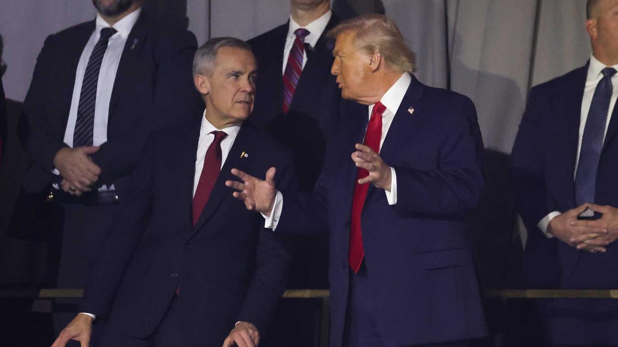 Canadian Prime Minister Mark Carney stands next to US President Donald Trump at an event