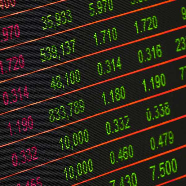 Digital screen showing financial data with green and red numbers.