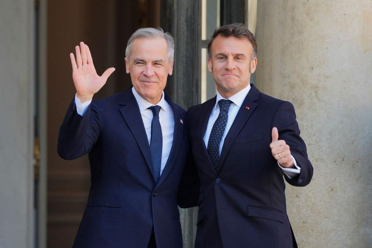 Mark Carney and Emmanuel Macron stand together and wave