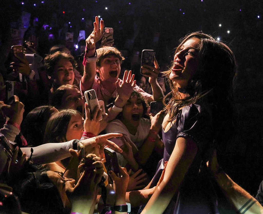 Olivia Rodrigo performs as dozens of fans scream and hold their phones up