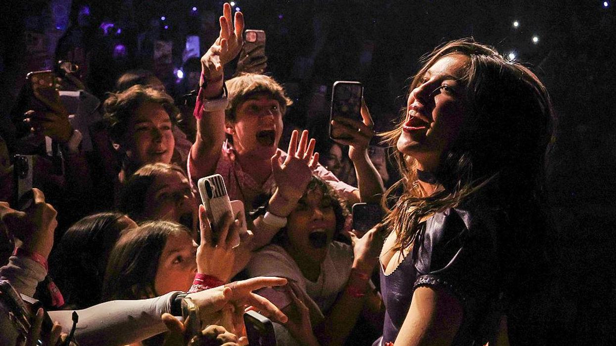 Olivia Rodrigo performs as dozens of fans scream and hold their phones up