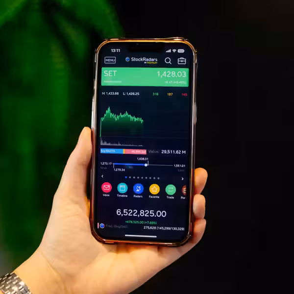 Person's hand holding a phone showing their investment app activity