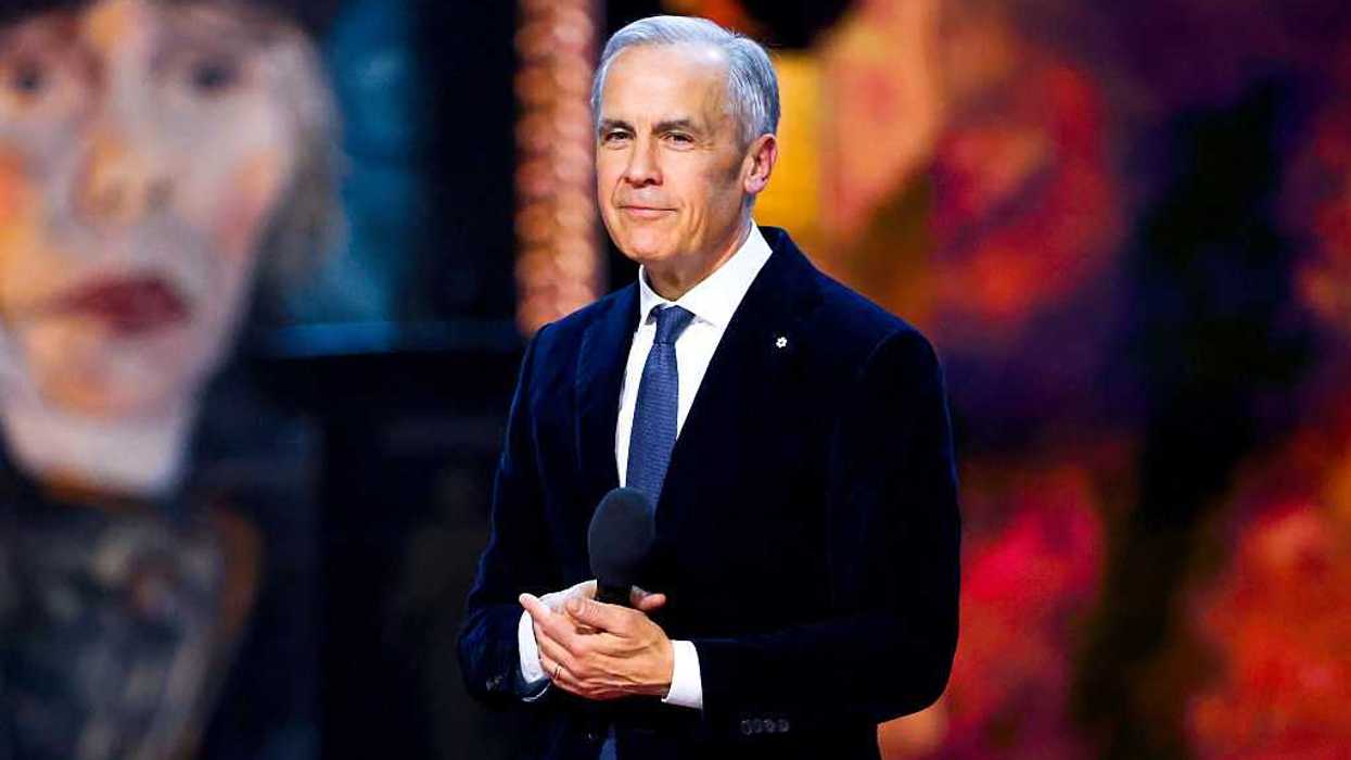 Prime Minister Mark Carney wearing Order of Canada pin, holding microphone