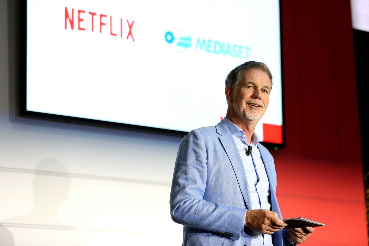 Reed Hastings standing on stage at a Netflix event