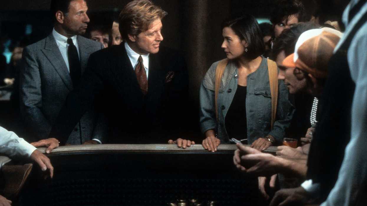 Robert Redford and Demi Moore intently face each other at a casino table