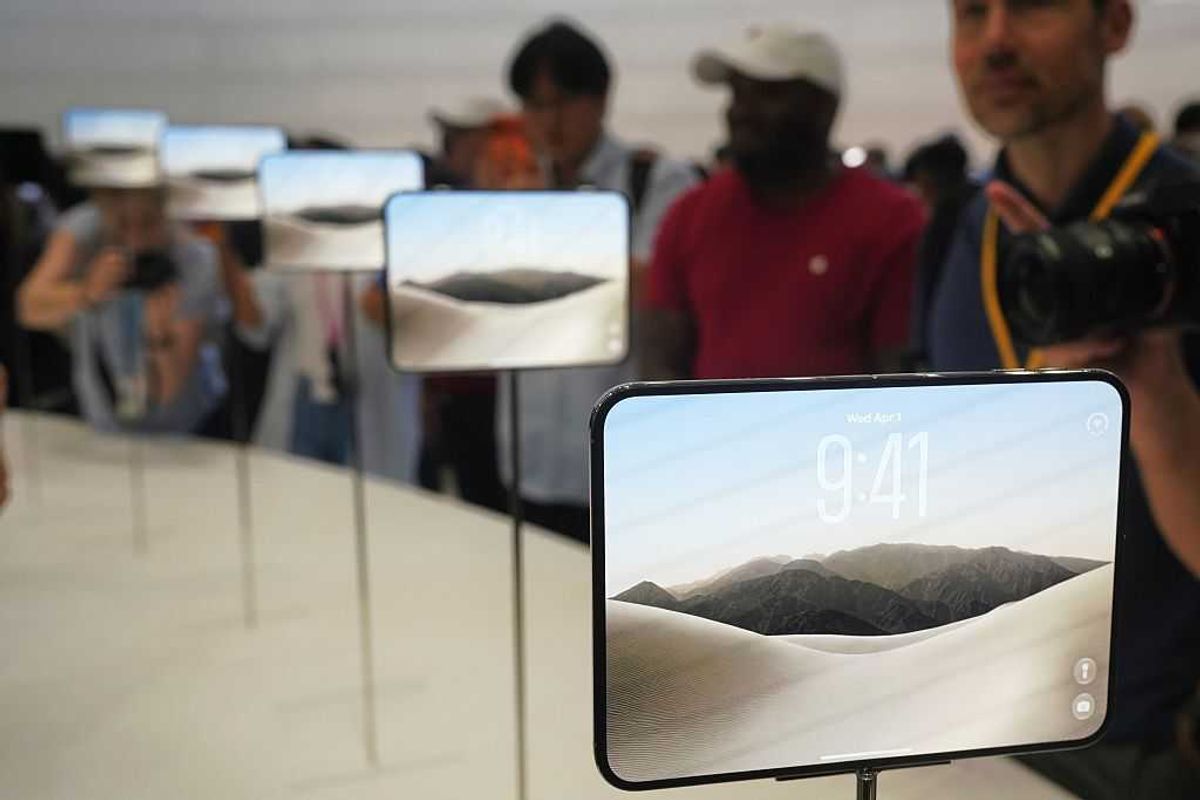 Several folding iPhone Duos on display on a table as people take photos