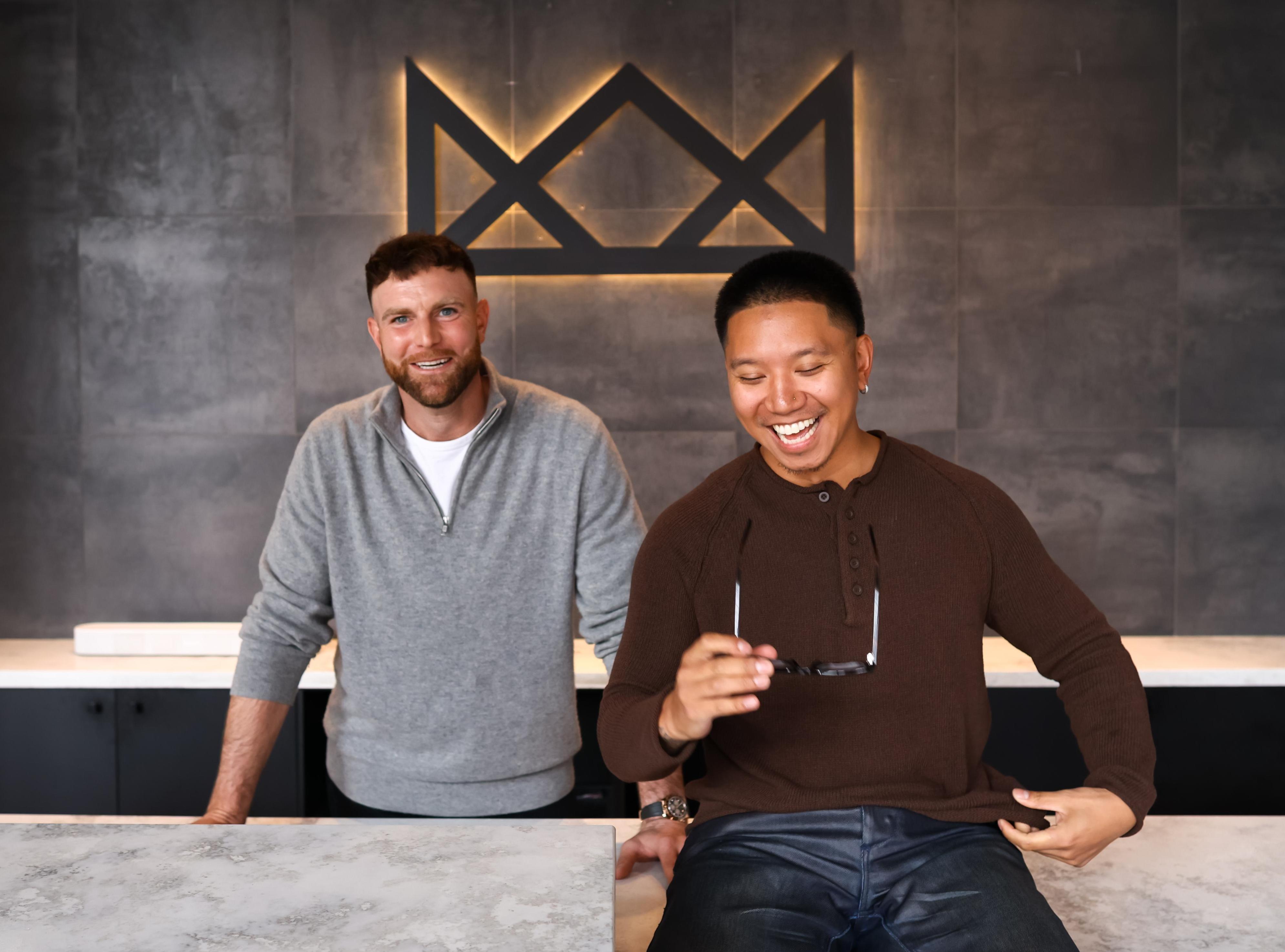 The owners of Throne Barbershop smile at the reception area