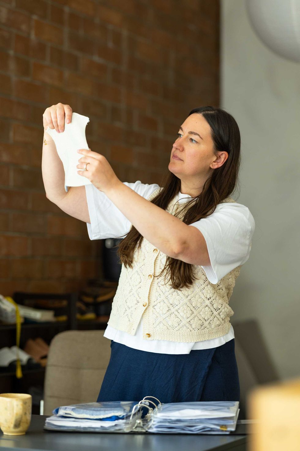 Woman looks at fabric samples at a desk